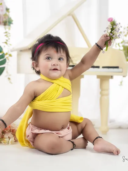 Offering a flower to the world. This sweet pose captures the gentle and curious nature of a one-year-old.