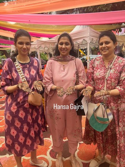 Three happy guests showing their matching mehendi. Coordinating designs for the bride's closest friends is a wonderful way to celebrate their bond.
