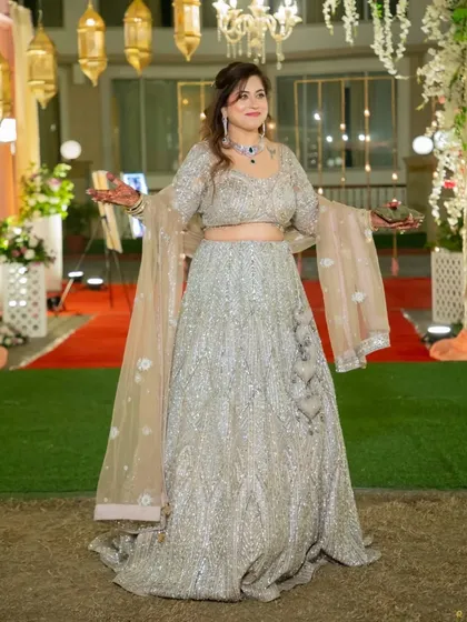 Our client looks absolutely breathtaking in this heavily embroidered silver lehenga. It's a perfect choice for an engagement or reception party, offering a grand look that is now affordably yours to keep.