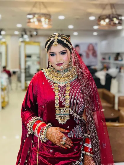 A front-facing portrait of the bride, highlighting the symmetry and perfection of her makeup and the stunning details of her jewelry.