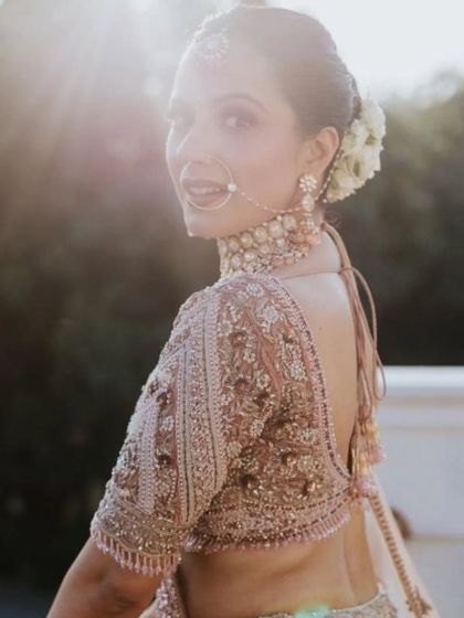 A beautiful back shot of the bride, showcasing her intricate blouse and elegant hairstyle.