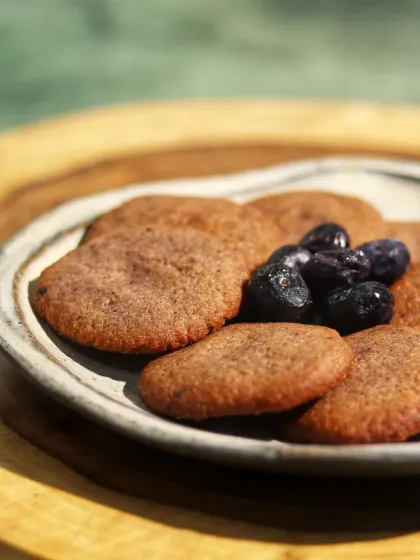 This is our Brown Butter Blueberry Cookie, a sugar-free, vegan, and high-protein delight. We use brown butter for its rich, toasty flavor and antioxidant properties, while blueberries add a burst of vitamins. Each cookie contains 31 grams of protein.