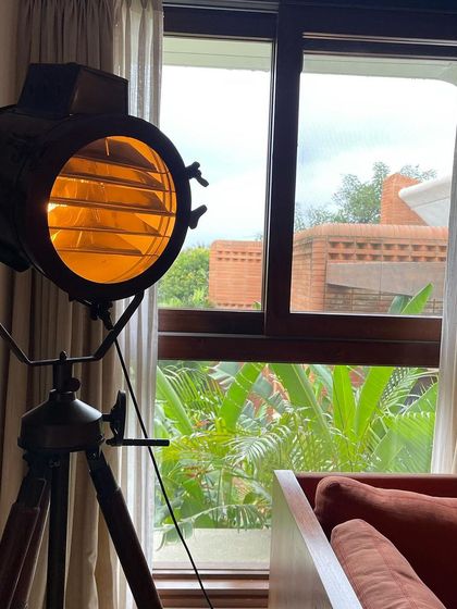 It's all about the details. A vintage style tripod lamp adds character to this living space, which looks out onto a private, green view.