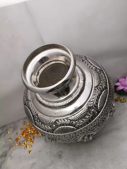 A top view of an antique German silver bindige (pot), showing the intricate carvings and the wide mouth, perfect for holding holy water.