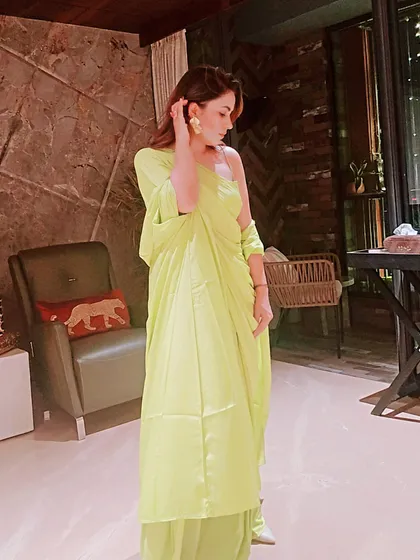 A full-length view of this unique neon green ensemble, showing how the pants and draped top work together. This is a perfect example of styling for a festive party where you want to be comfortable and chic.