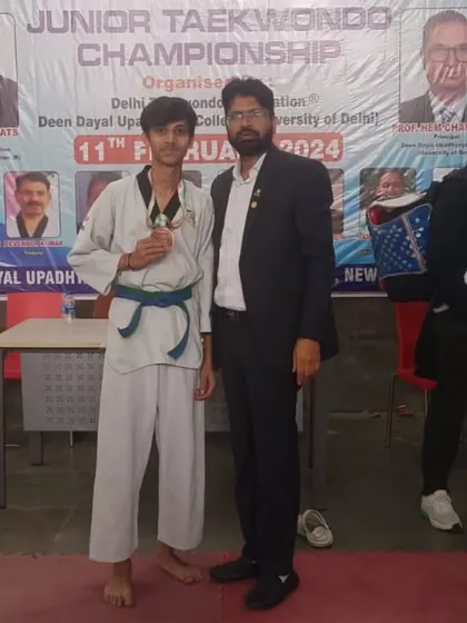 A junior student with his bronze medal at the Delhi Olympic Games. Consistent participation in tournaments builds resilience and skill.