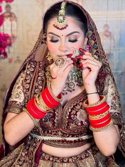 A playful bridal pose showing off the detailed makeup and jewelry. Notice the perfectly defined lips and the subtle glow on her skin.