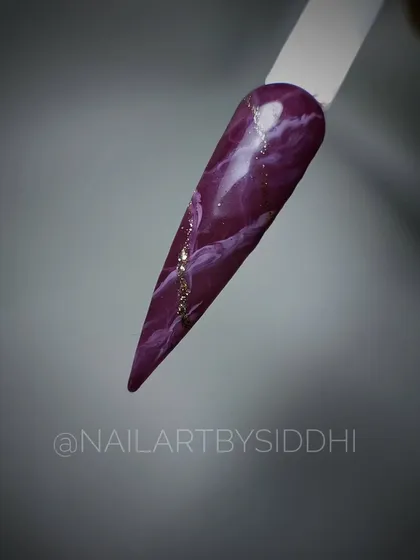 A deep purple marble design with a hint of gold, created on a sample tip to show the technique.