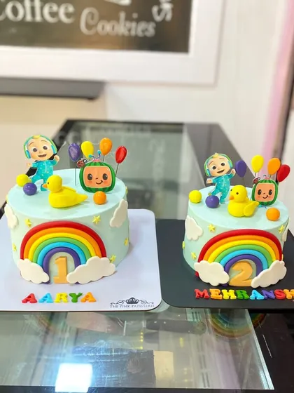 A pair of adorable Cocomelon cakes for two different birthdays. These matching designs feature rainbows, clouds, and characters from the popular children's show.