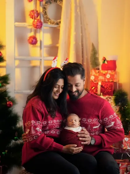 A cozy, festive family portrait with a newborn. I create warm and inviting indoor setups for special occasions like Christmas, capturing your family's first memories together.