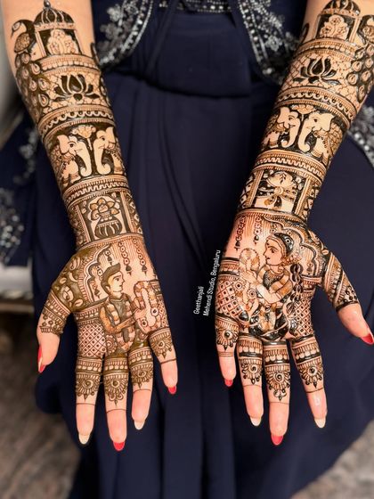 A full view of the hands, showing how the portraits are integrated into a larger, traditional bridal design with elephants and lotuses.