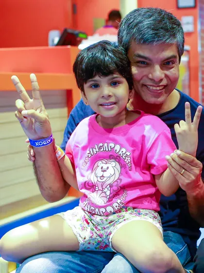 A father and child duo flashing peace signs, enjoying some quality time together on Father's Day.