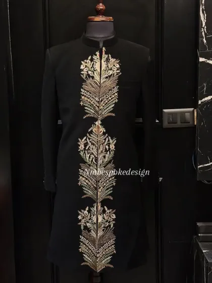 This black indowestern jacket is defined by a central panel of heavy, gold and silver feather-like embroidery, creating a regal and commanding presence.
