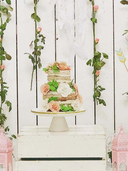 A beautiful naked cake for a boho-chic baby shower. The simple, rustic style of the cake, adorned with fresh roses, perfectly matched the bohemian theme.