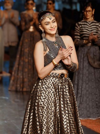 A joyful, candid moment of Mrunal Thakur clapping on the ramp. This shot reveals her charming personality behind the fierce model persona.