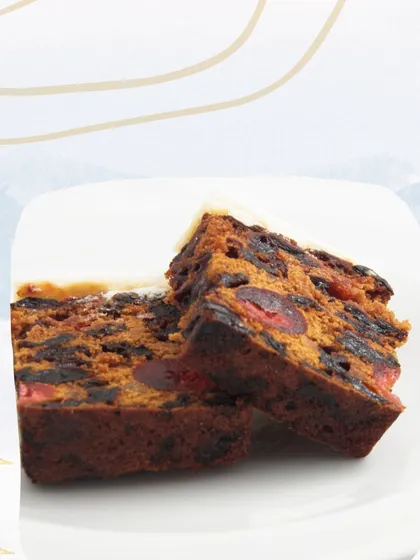 A perfect slice of my alcohol-free Christmas plum cake. Notice the rich, dark crumb and the generous distribution of candied fruits, showing the quality and care I put into this traditional recipe.