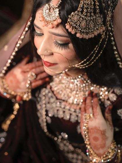 A stunning close-up of a Muslim bride, highlighting her intricate jewelry, beautiful makeup, and the rich fabric of her wedding attire.