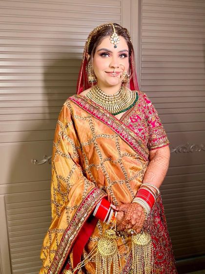 A close-up portrait of Sakshi, highlighting her soft smokey eye and the beautiful details of her nath and maang tikka.