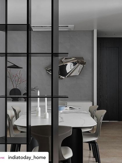 This perspective, seen through the room divider, creates a sense of discovery. The dining area and its feature art piece are revealed gradually, making the space feel more intimate and intriguing.