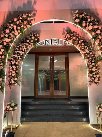A modern and romantic entrance featuring nested arches with LED lighting and beautiful floral arrangements, creating a glowing gateway.