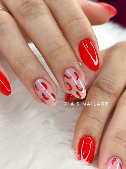Red chili nails for a vacation. This fun set features a bright red gel overlay on natural nails with a spicy, hand-painted chili pepper accent.