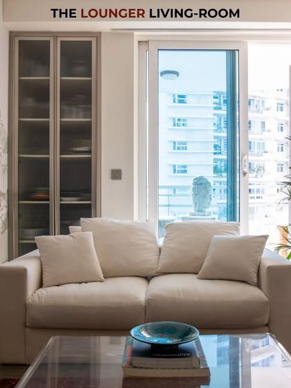 The lounger living room is a favourite spot to relax. The custom art wallpaper, comfortable sofa, and ample natural light make it a perfect urban retreat.