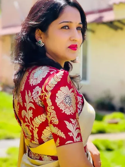 A close-up of the red brocade blouse, showing the rich texture and pattern of the fabric.