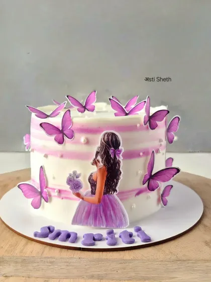 A simple yet elegant butterfly cake with purple stripes and a silhouette topper. The butterflies seem to flutter around this whipped cream cake.