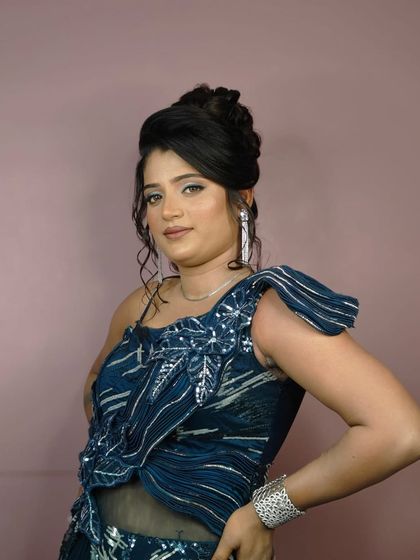 A close-up of the client's makeup and the stylish one-shoulder design of the blue outfit.