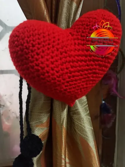 A simple and sweet curtain tie-back featuring a big, plush red heart. It's a lovely way to add a pop of color and love to your room's decor.