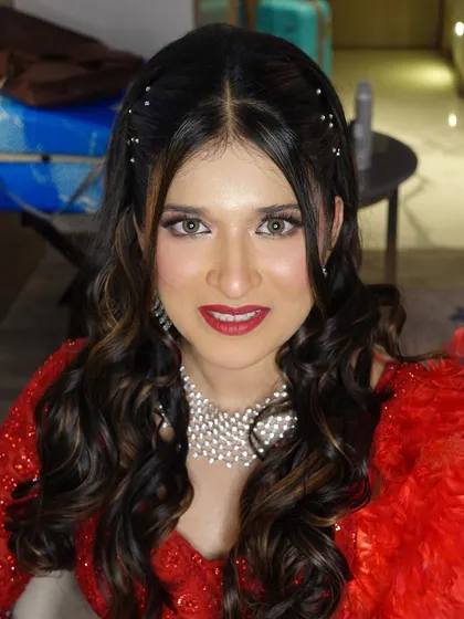 A happy and radiant Amileen, showing off her Sangeet look. The red lip and sparkling eyes are perfect for the occasion.