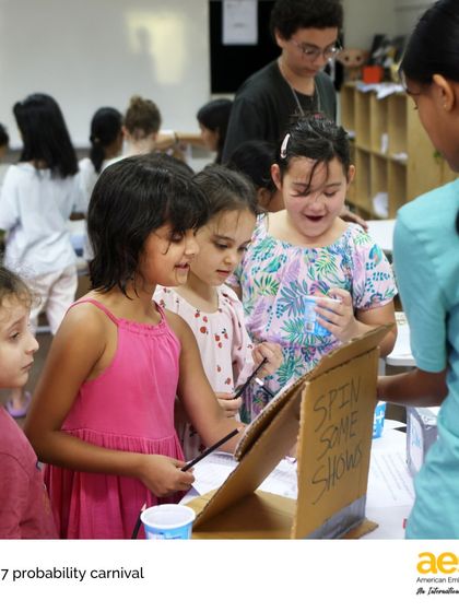 Younger students eagerly line up to play a game at the Grade 7 Probability Carnival. This event is a highlight of the year, blending math, creativity, and community.