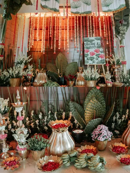 A stunning, dense arrangement of traditional elements like banana leaves, rajnigandha flowers, and brass vessels.