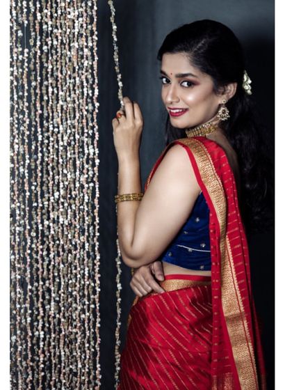 A playful and engaging portrait of the model interacting with a shimmering curtain backdrop. Her smile and pose add a touch of charm to the festive series.