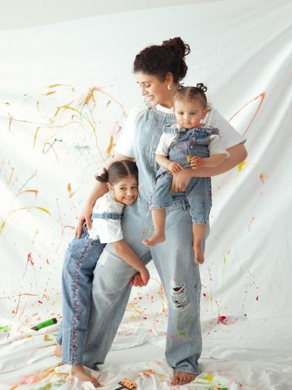 A colorful take on a timeless moment. Even with splashes of paint, the focus remains on the loving connection between this mother and her two girls.