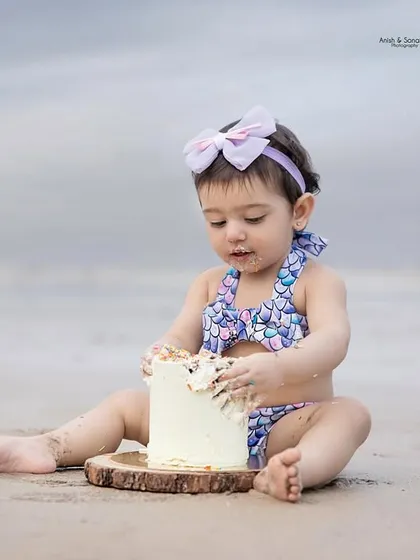 Getting right into it! This shot captures the moment of intense focus as she explores the texture of her first birthday cake.