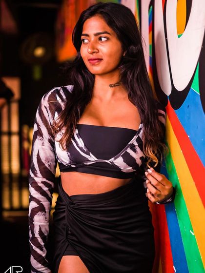 A guest in a zebra-print top, posing by the colorful wall.