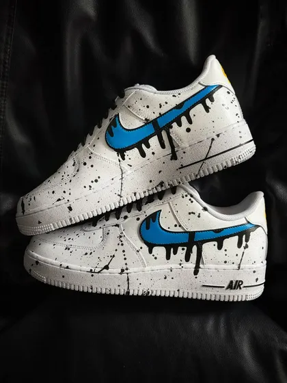 A custom Nike Air Force 1 with a blue dripping swoosh and black paint splatter.