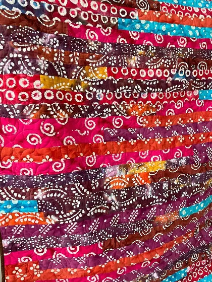 A close-up of the batik Jelly Roll quilt, showing the rich colors and patterns.