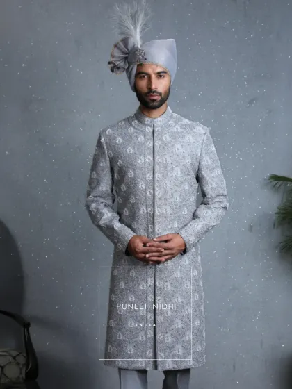 Hand embroidery breathes soul into every detail. This powder blue sherwani, with its blooming florals, is tradition reborn. The turban and sarpech complete its regal presence.