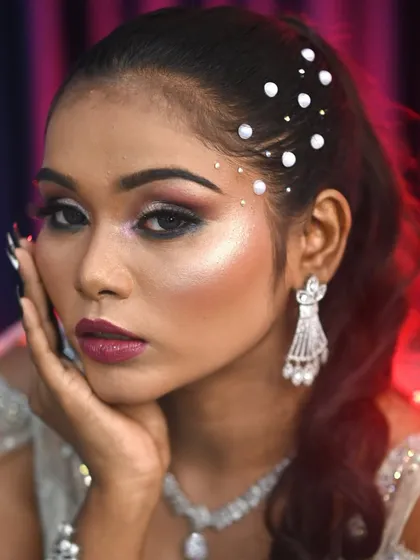 A photo of a glamorous makeup look with pearl hair accessories and dramatic eye makeup.