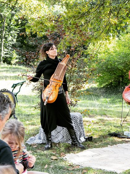 An artist plays the Nyckelharpa for an audience of children and parents. We love introducing unique instruments to our audiences during our family-friendly shows.