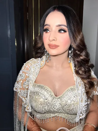 This engagement look features a white and silver lehenga, styled with long, dangling pearl and diamond earrings.