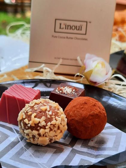 A beautiful plate of our assorted chocolates, including a cocoa-dusted truffle, a nut-covered praline, and a ruby chocolate piece. This user-shared photo shows how our chocolates are perfect for any moment of indulgence.