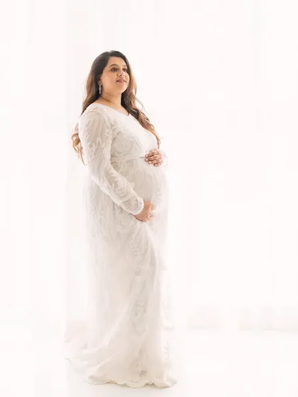 Angelic in white. This high-key portrait against a bright white background has a light, airy, and ethereal feel. The delicate lace gown adds to the gentle mood.