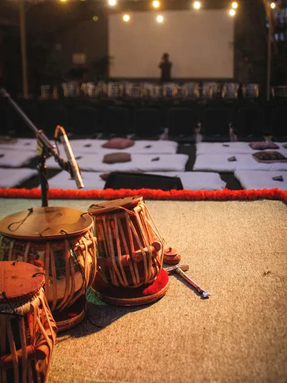 Another view of the stage before a concert begins. This perspective shows the preparation and care that goes into creating the perfect baithak environment for both artists and listeners.