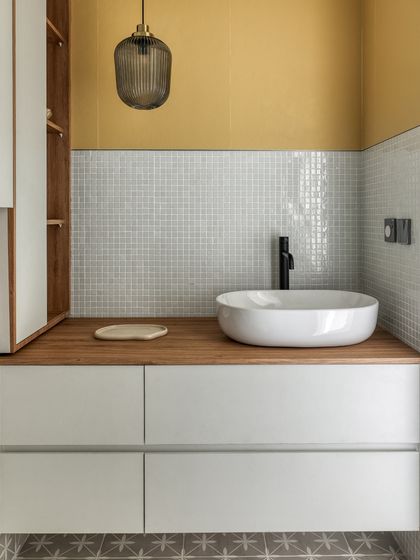 A closer look at the bathroom vanity. Handle-free cabinetry and a floating vanity create a sleek, uncluttered look, while the wooden countertop adds a touch of natural warmth.