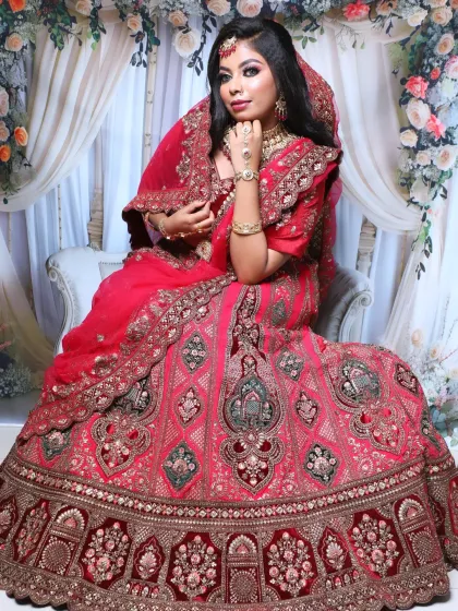 This full-length shot showcases the magnificent red velvet lehenga with its detailed embroidery. The makeup and styling are designed to be grand and impactful.