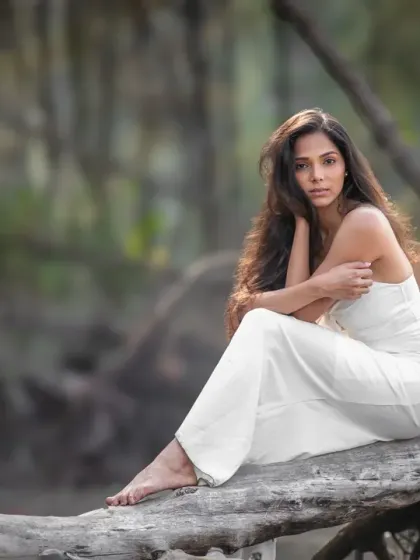 A close-up from the editorial shoot, focusing on the model's intense gaze. The natural, wild background contrasts beautifully with her serene expression.