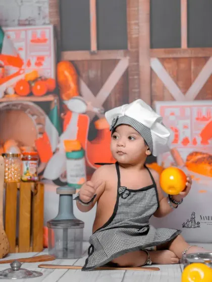 A thumbs-up from the chef. This pose shows the baby's happy and confident personality shining through during the themed kids' photoshoot.